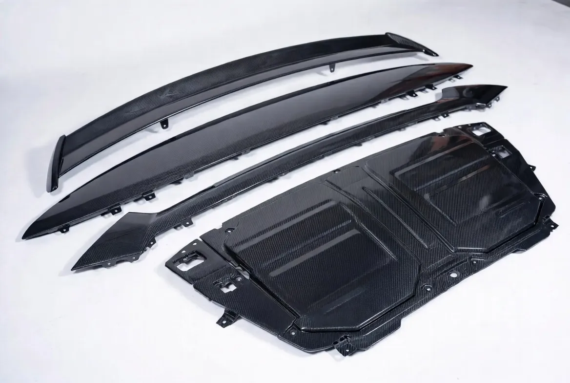 Carbon fiber, glass fiber and SMC composite layup, CNC trimmed automotive parts including body panels, hoods, spoilers, structural reinforcements and EV battery enclosures with woven carbon texture and painted surfaces on clean white background